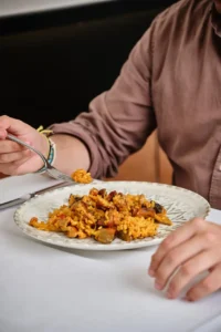 Comensal degustando arroz de secreto ibérico con setas y pimientos en Restaurante La Tartana de Cartagena
