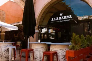 Entrada y terraza con mesas altas de A La Barra Gastrobar en Cartagena