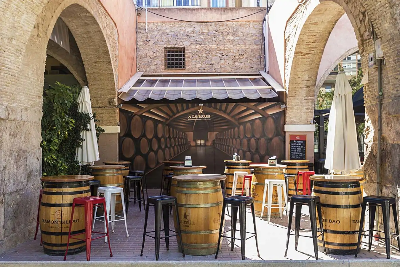 Terraza con barriles y mesas altas del bar de tapeo A La Barra Gastrobar en el centro de Cartagena